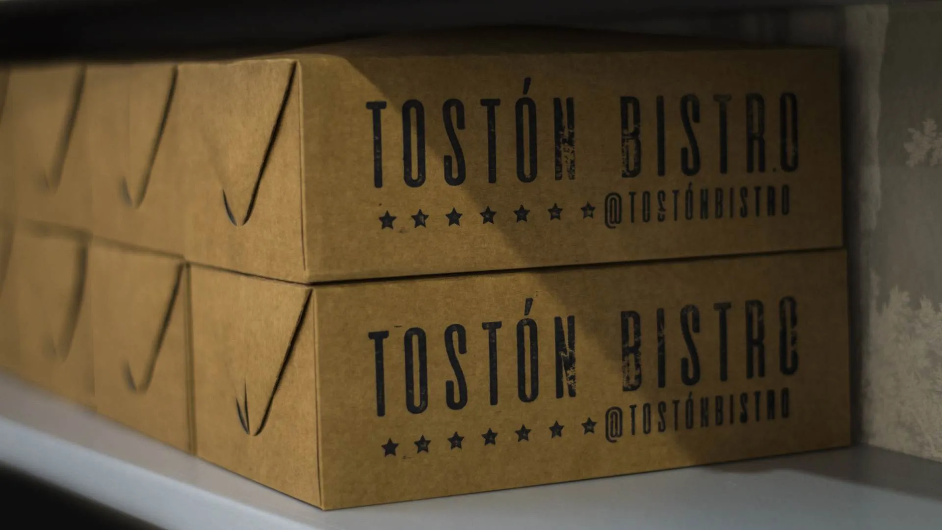 Cajas para llevar con el logo de Tostón Bistro